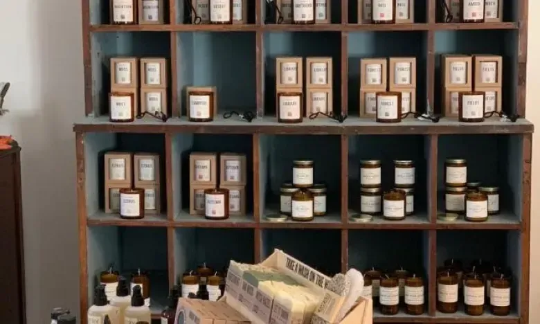 Shelves filled with jars and boxes, with newspapers in a basket below.