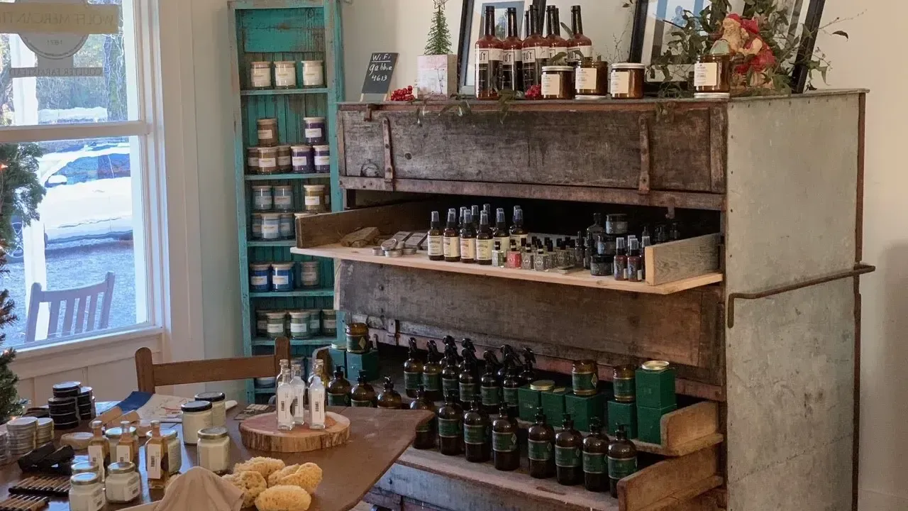 Rustic shelf with bottles and jars in a cozy shop setting.