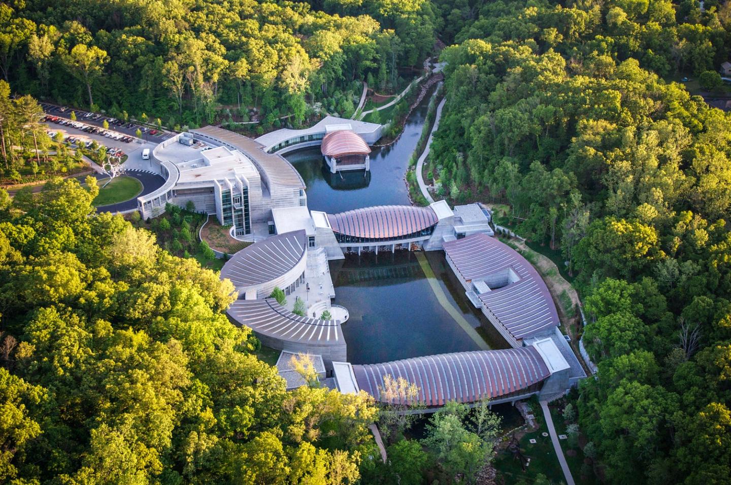 Aerial view of a modern building complex surrounded by lush green forest.