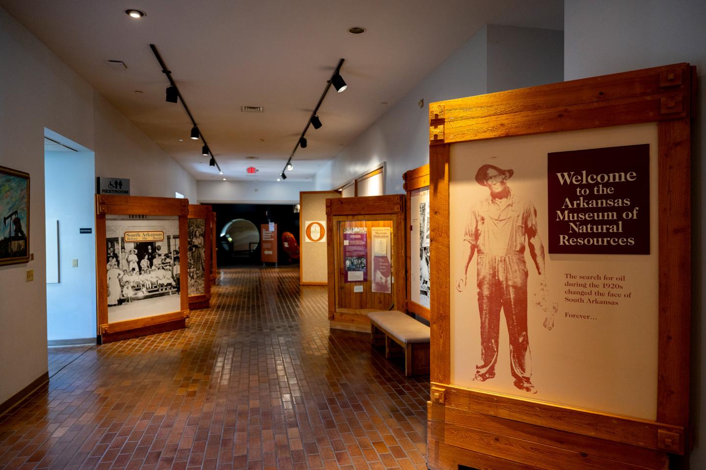 Hallway in a museum with informational displays and wooden floor.