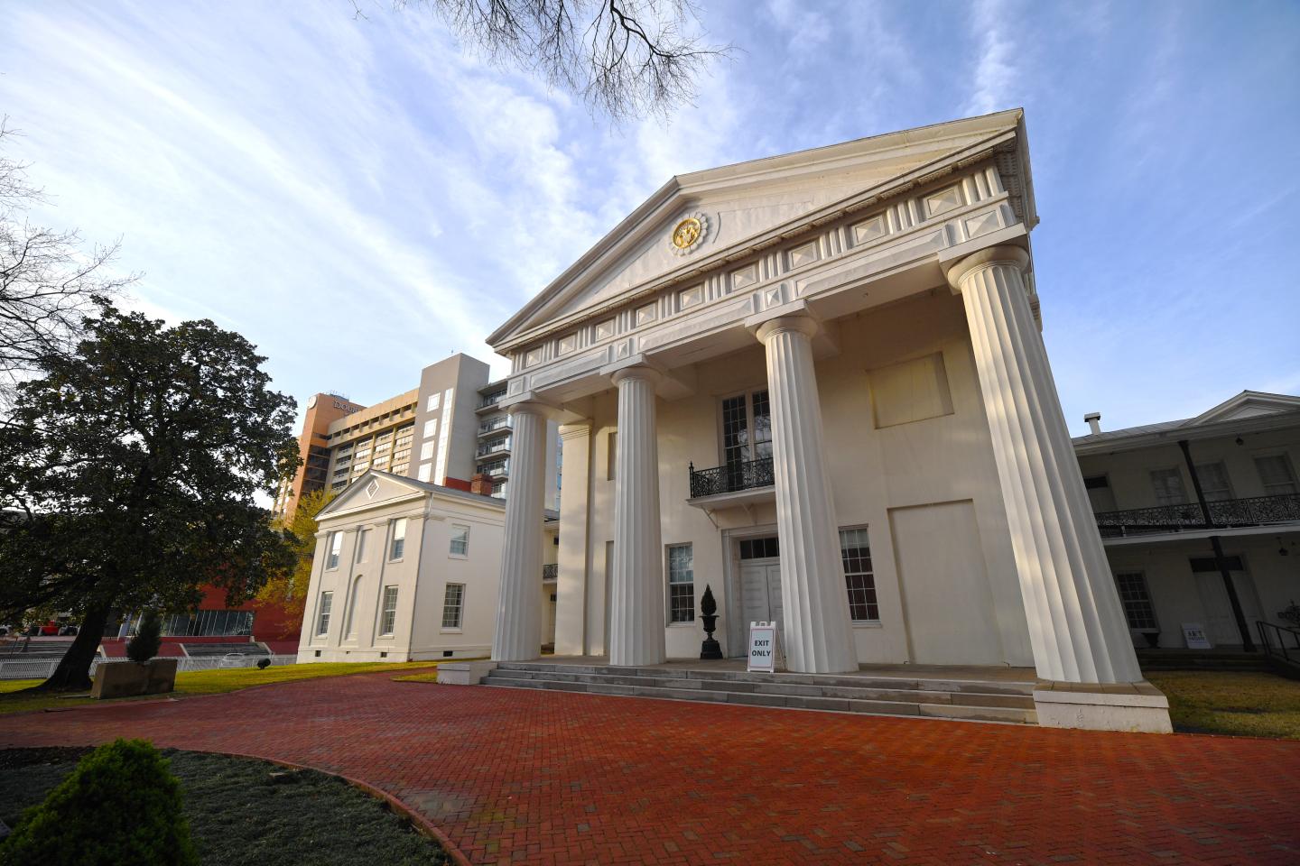 Historic building with large pillars under a blue sky.