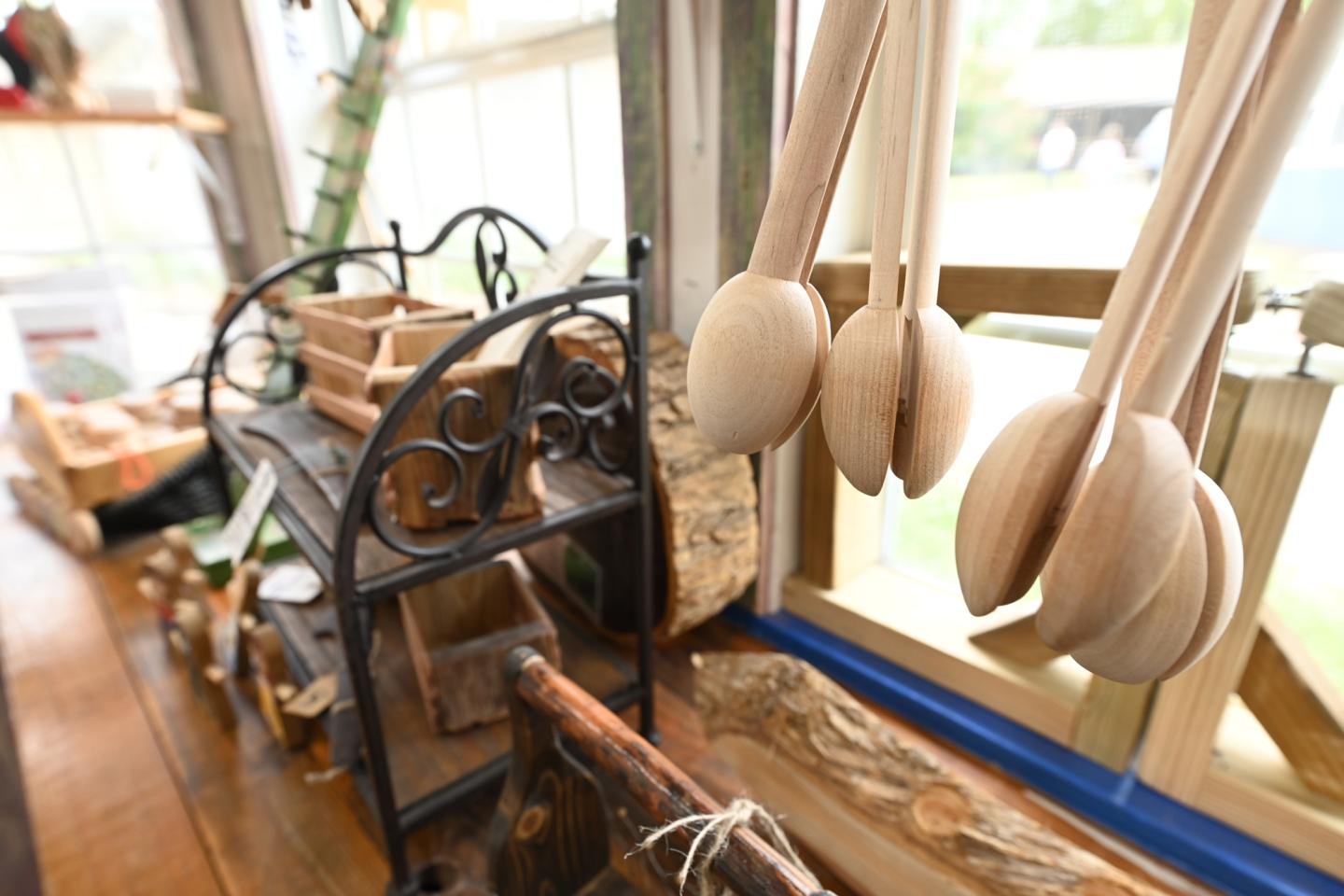 Wooden spoons and kitchenware on shelves by a sunny window.
