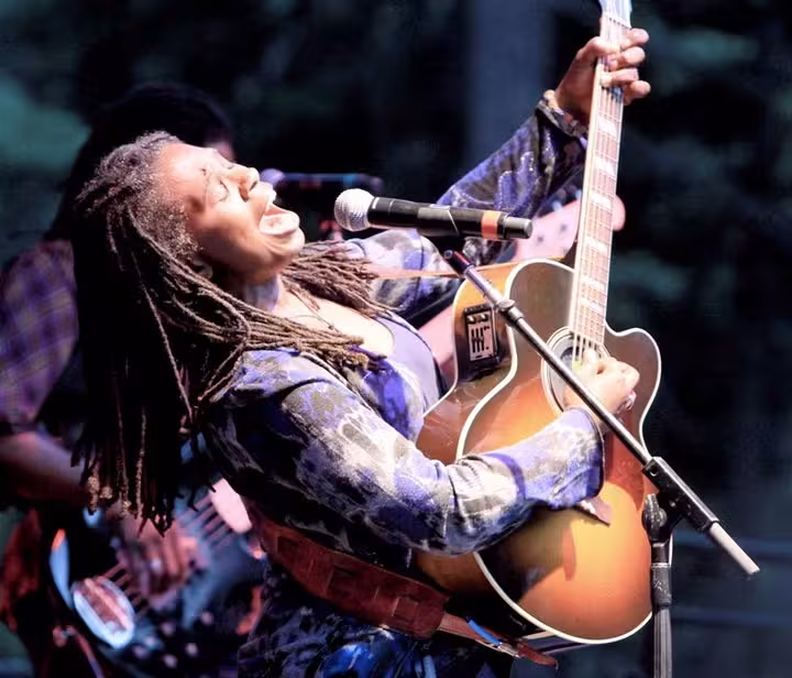 Musician passionately playing guitar on stage.