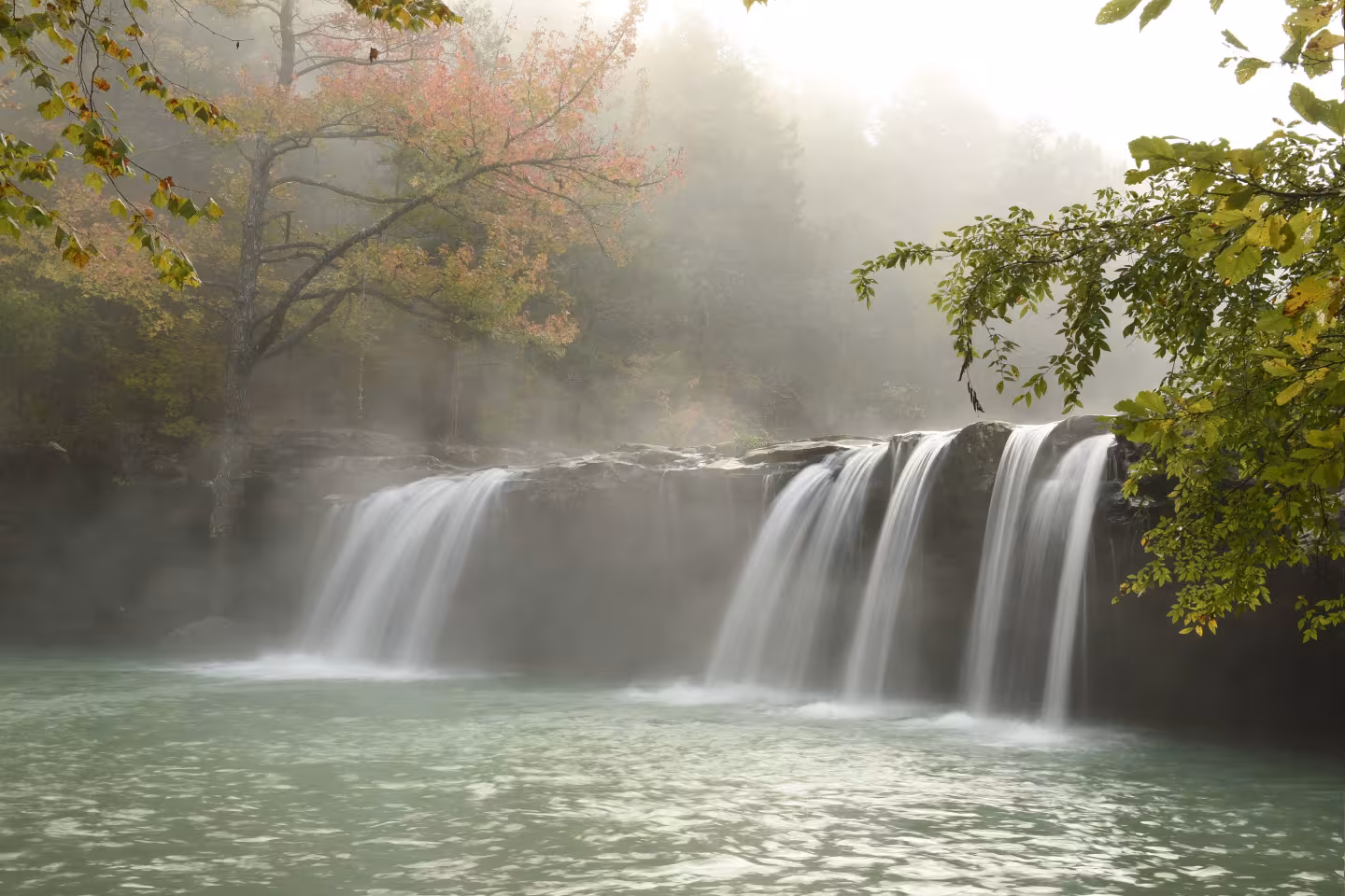 Waterfall with mist and autumn trees.