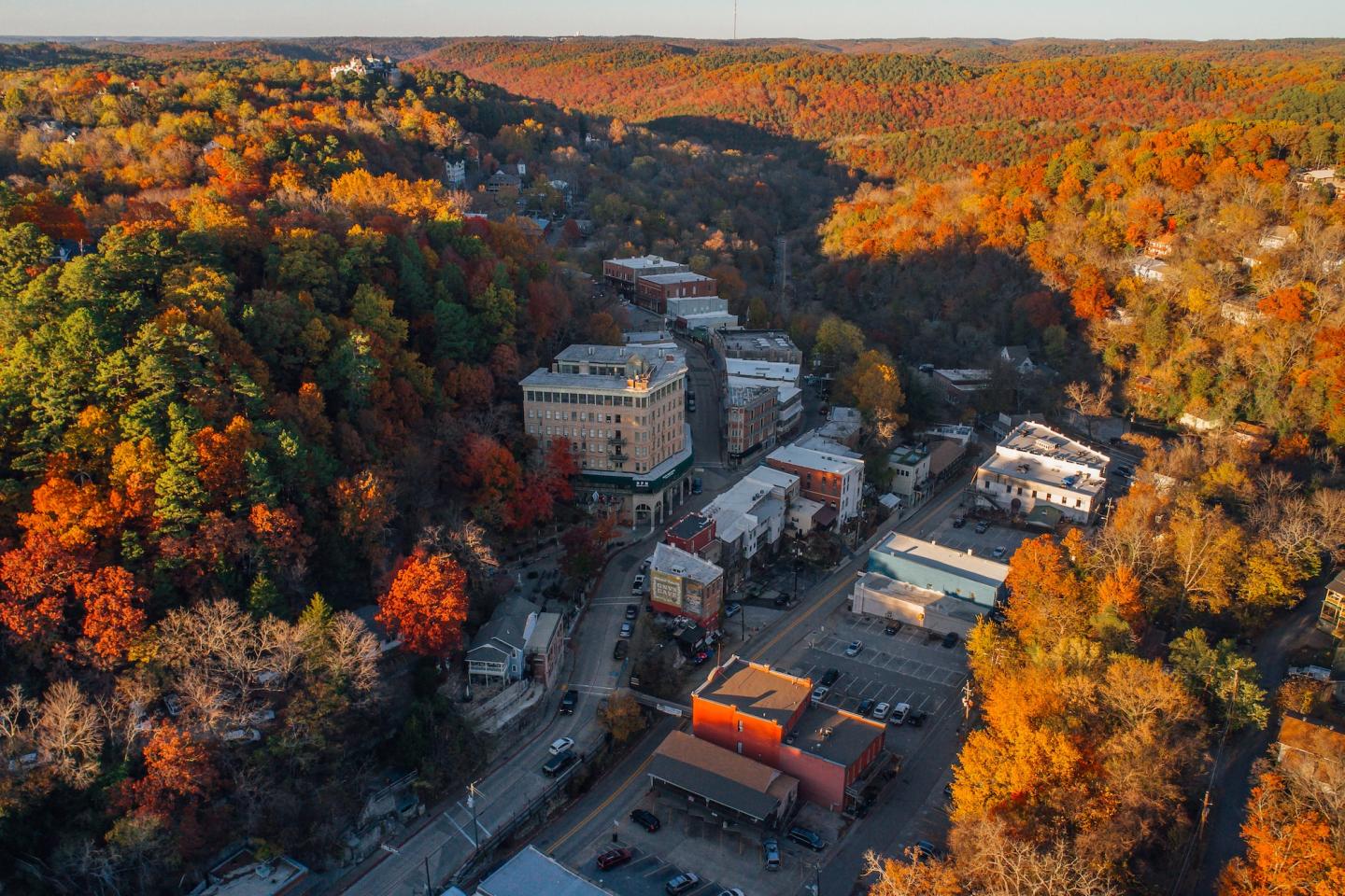 Aerial view of a town with autumn foliage and colorful trees.
