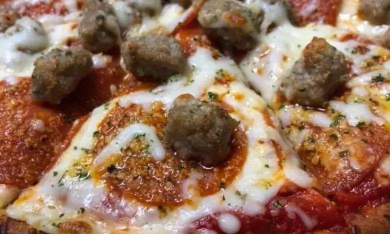 Sausage and pepperoni pizza slice with melted cheese.