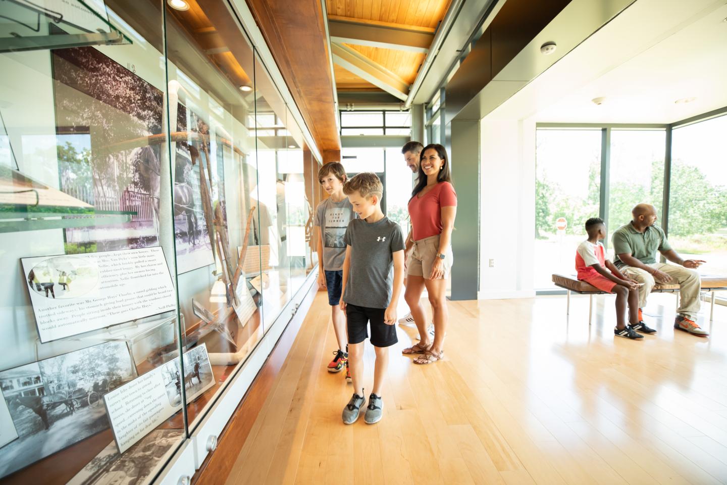 Family viewing museum exhibition in bright room.