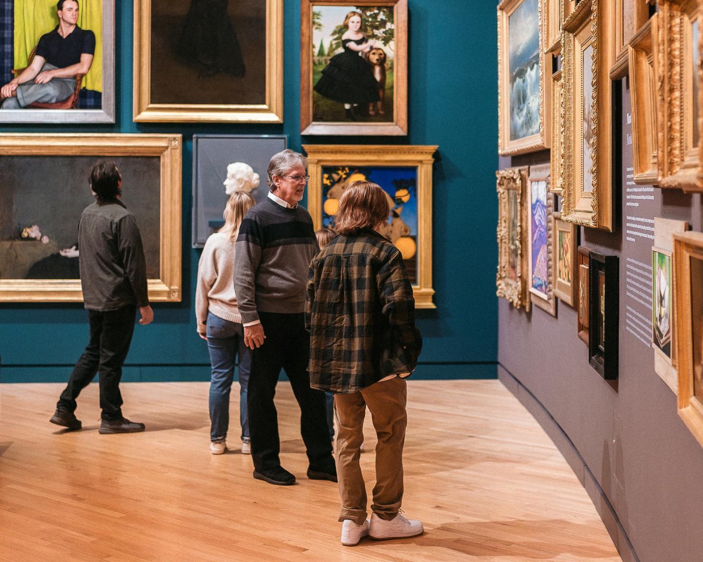 Visitors admiring artwork in a museum gallery.