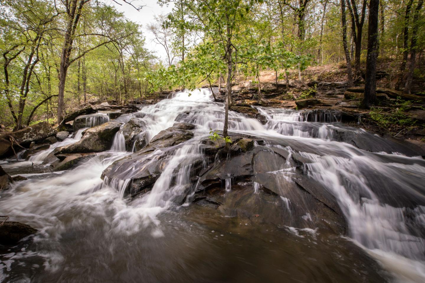 Waterfall cascading over rocks in a forested area.