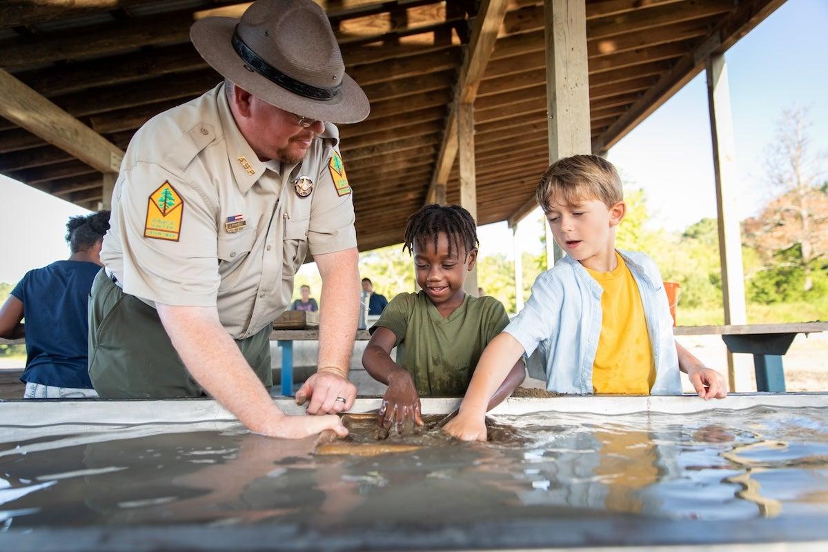 Ranger and children panning for diamonds