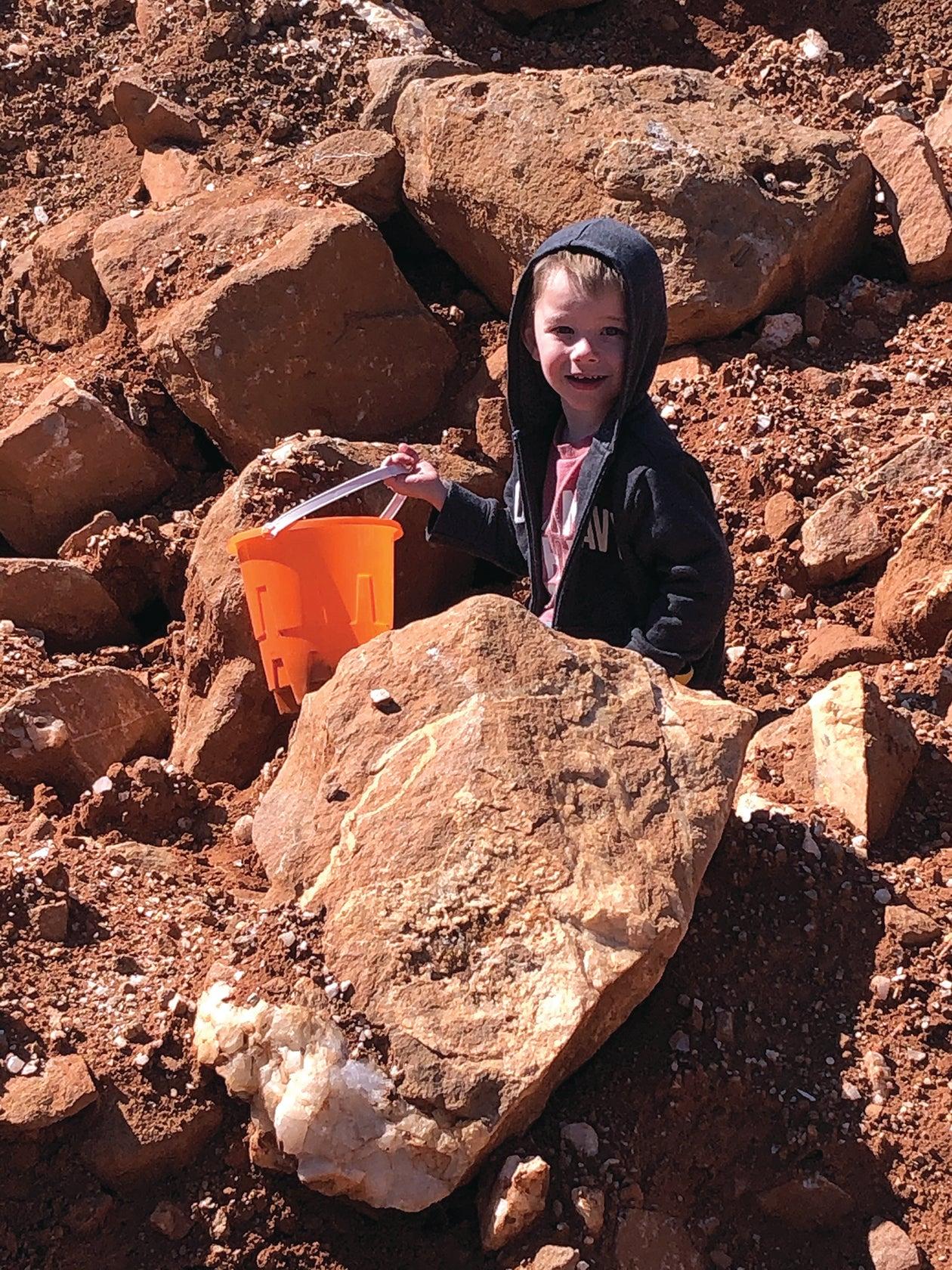 Person with bucket outside at Ron Coleman Mine