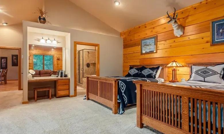 Cozy rustic bedroom with wood-paneled walls, double bed, and soft lighting.