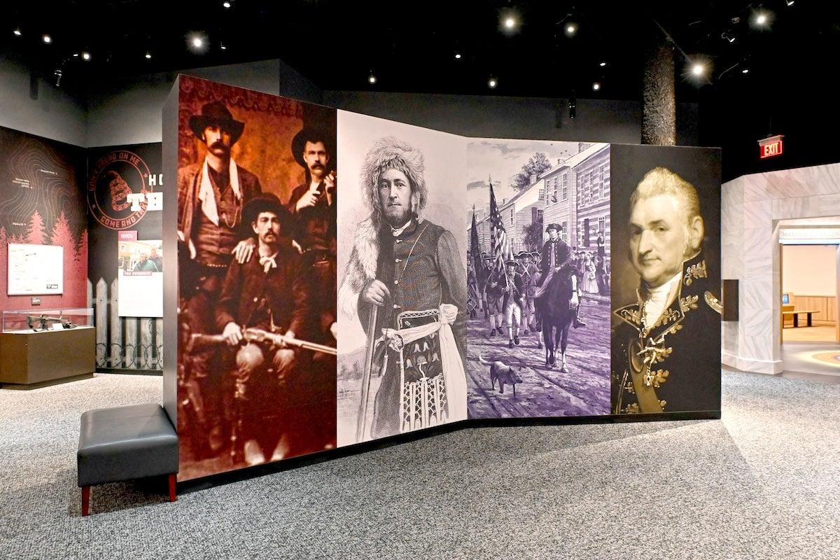Historical photo display in a museum with portraits of various figures.