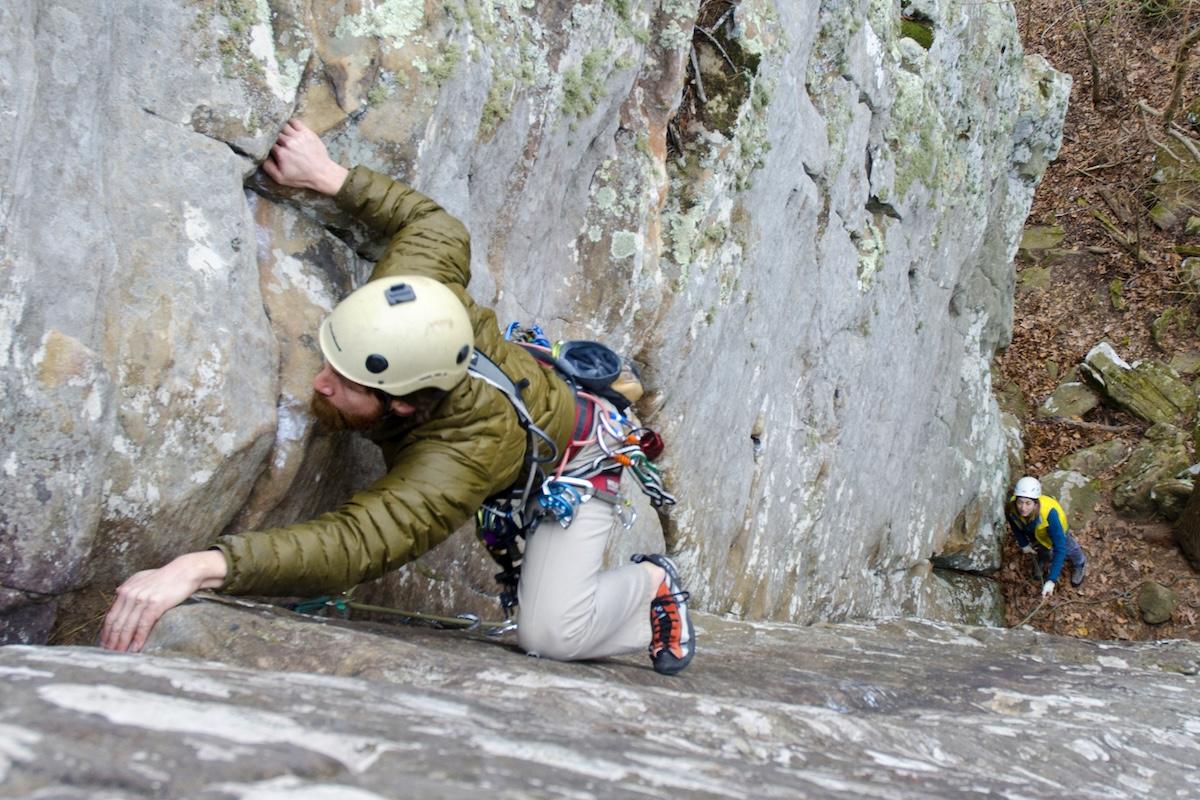Rock climber ascending a steep cliff, second climber below.